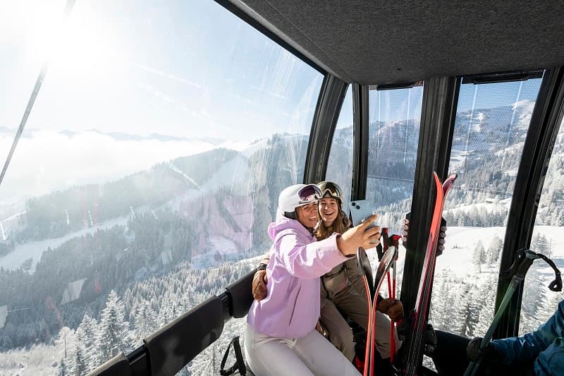 Zwei Gäste in der Gondel mit Blick über das Tal